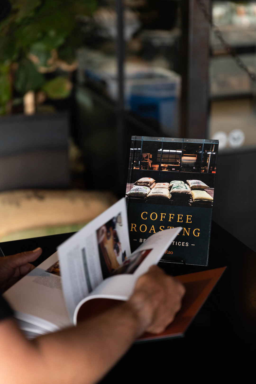 flipping pages of Scott Rao Coffee Roasting best practices book