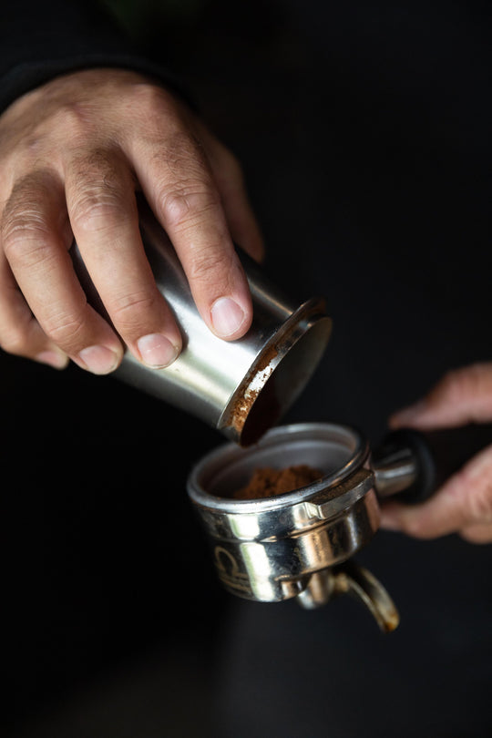 MAN POURING COFFEE IN TO ACAIA PORTAFILTER DOSING CUP 