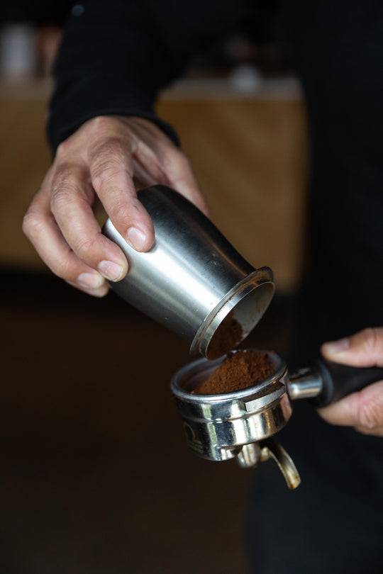 MAN POURING COFFEE INTO ACAIA PORTAFILTER DOSING CUP - MEDIUM