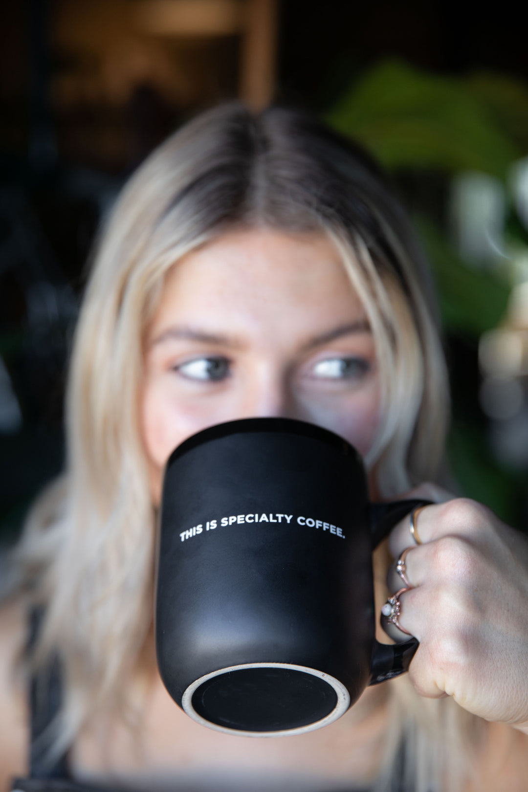 A LADY DRINKING WITH THE SPECIALTY COFFEE MUG